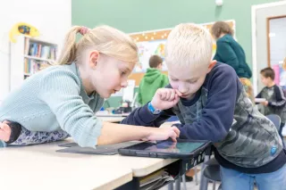 Primair Onderwijs - Kinderboekenweek - 2 kinderen in de klas gebogen over boek